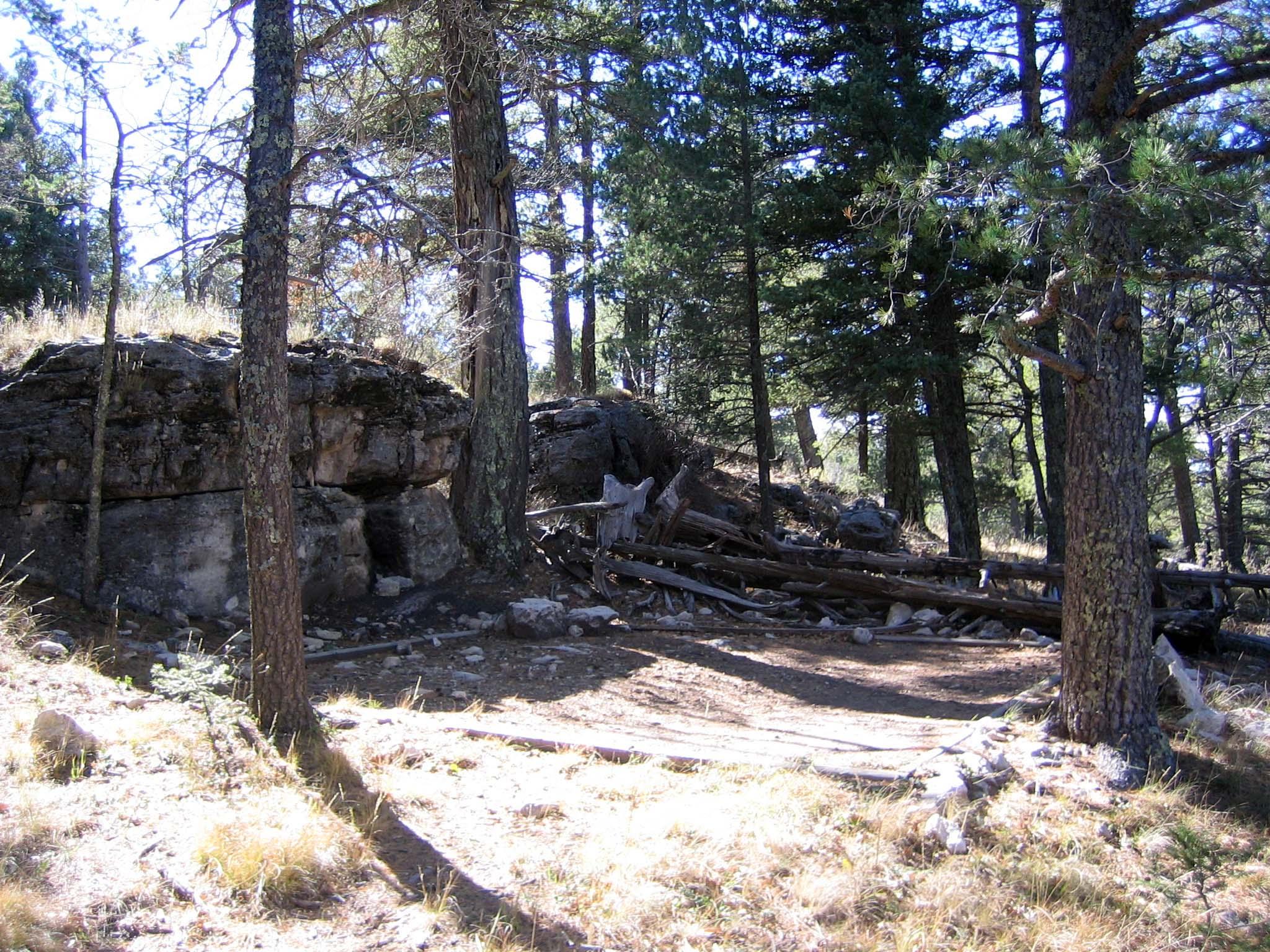 A small cliff rises above a hardened surface for a tent