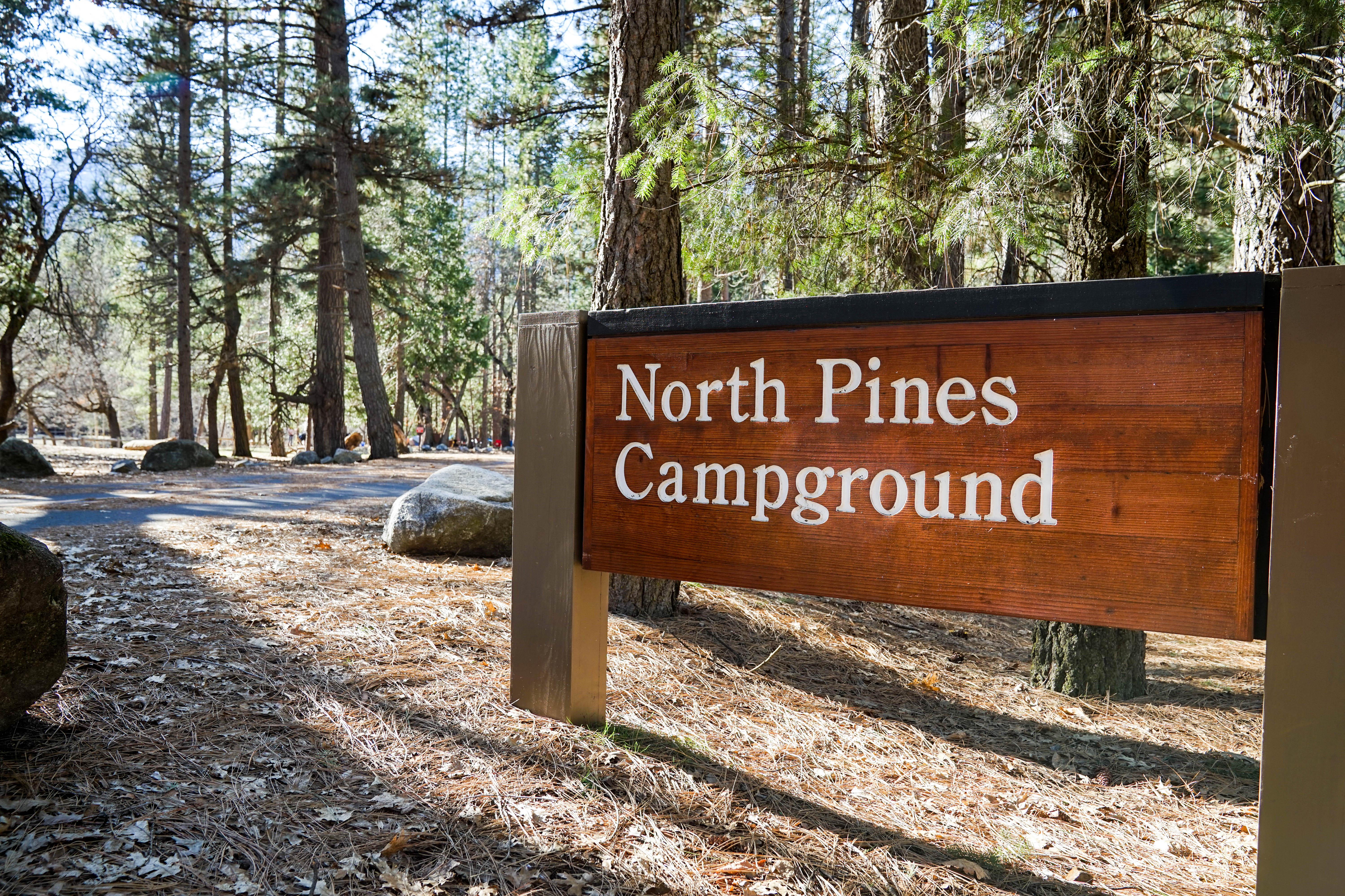 A wood sign at the entrance of a campground reads, North Pines Campground.