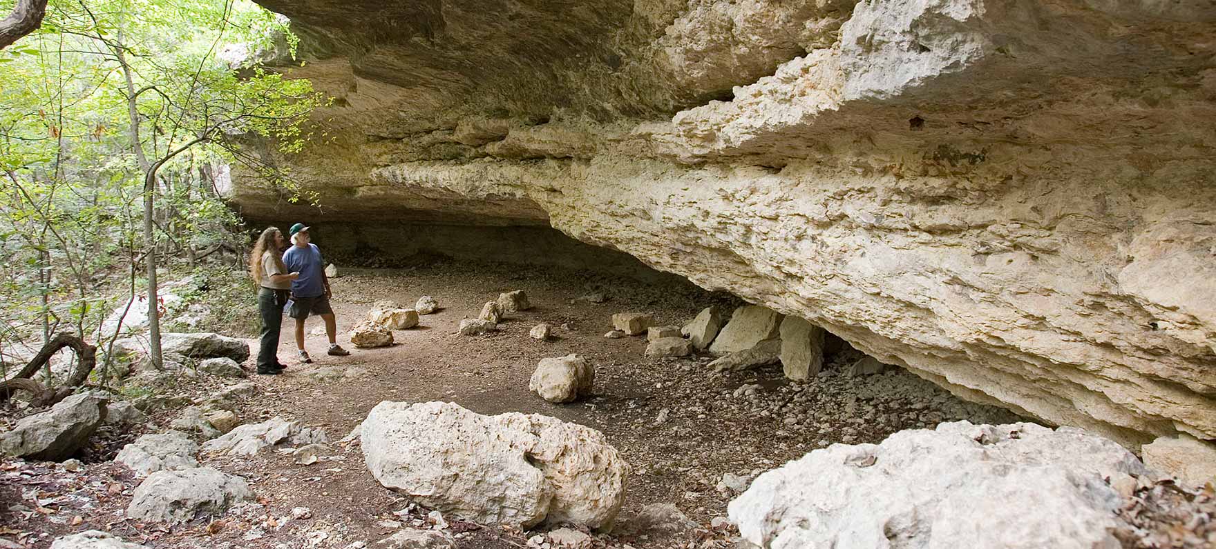 Ranger and visitor talking in rock shelter